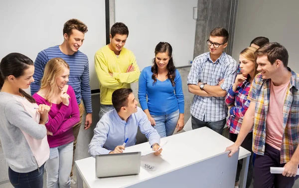 Students and teacher with papers and laptop — Stock Photo, Image