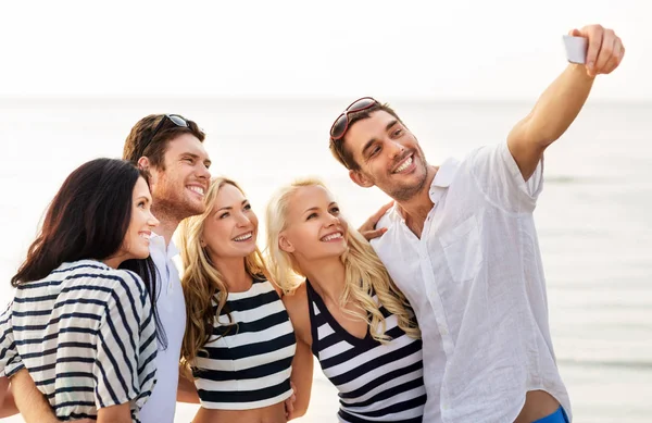 Happy friends taking selfie on summer beach Stock Photo