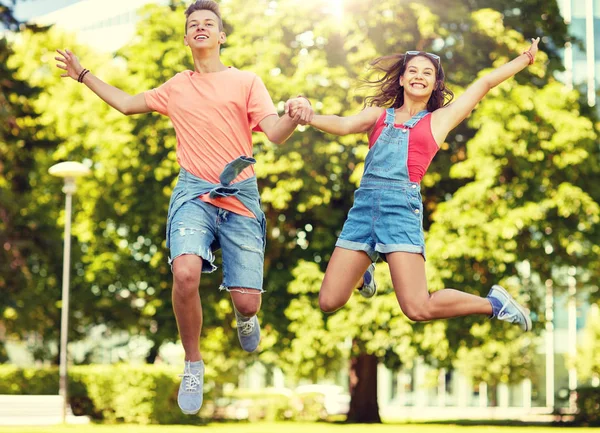 Счастливая пара подростков, прыгающих в летнем парке — стоковое фото