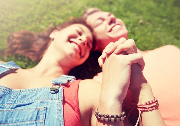 Happy teenage couple lying on grass at summer — Stock Photo, Image