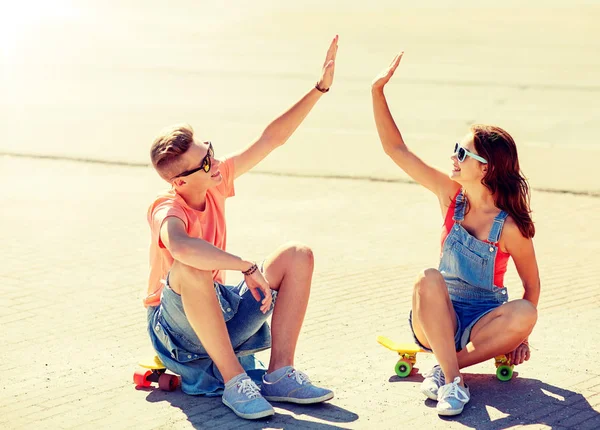 Pareja adolescente con patinetas en la calle de la ciudad —  Fotos de Stock