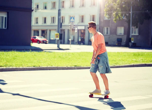 Dospívajícího chlapce na skateboardu přes město přechod pro chodce — Stock fotografie