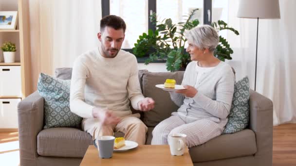 Senior Mutter und erwachsener Sohn essen Kuchen zu Hause — Stockvideo