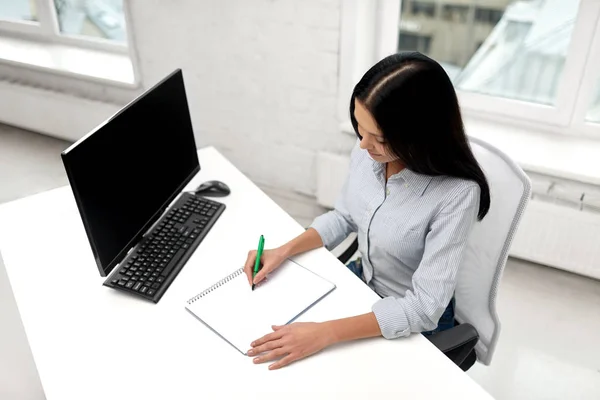 Geschäftsfrau schreibt im Büro ans Notizbuch — Stockfoto