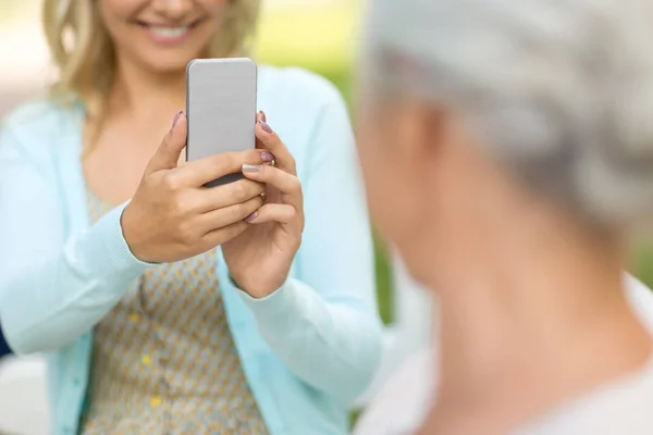 Dochter fotograferen senior moeder door smartphone — Stockfoto