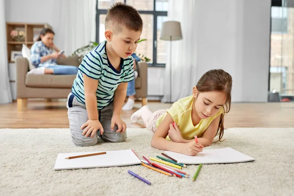 Fratello e sorella disegno con pastelli a casa — Foto Stock