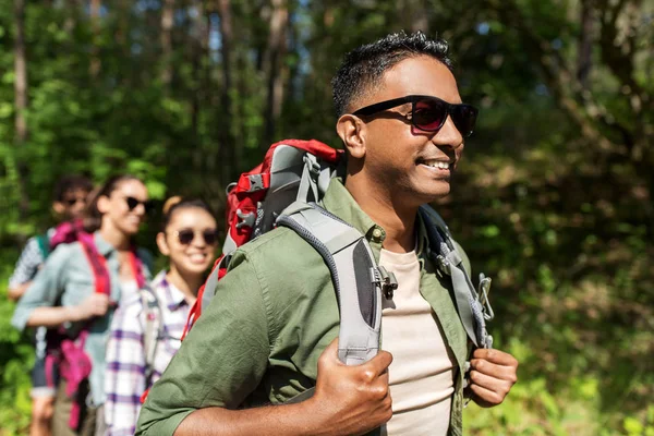 Grupo de amigos con mochilas senderismo en el bosque — Foto de Stock