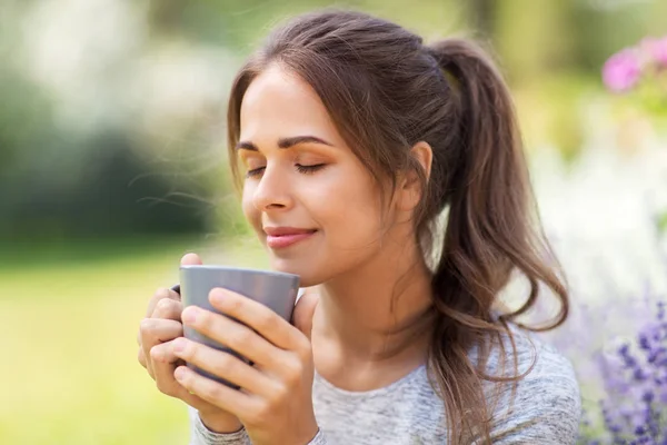 Kvinna dricker te eller kaffe på Summer Garden — Stockfoto