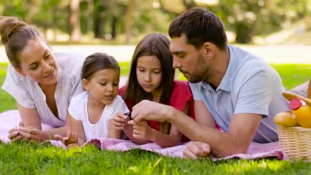 Familia acostada en una manta de picnic en el parque de verano — Vídeo de stock