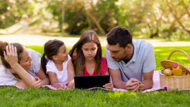 Семья с планшетным ПК на пикнике в летнем парке — стоковое видео