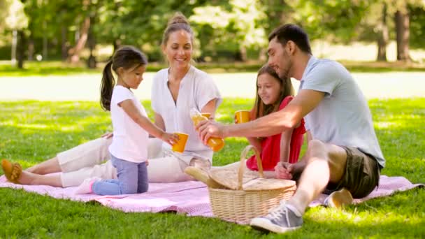 Lycklig familj dricka saft på picknick på Park — Stockvideo