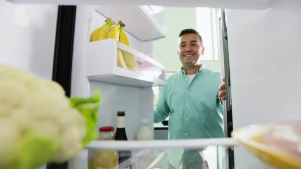 Homem tomando couve-flor da geladeira na cozinha em casa — Vídeo de Stock