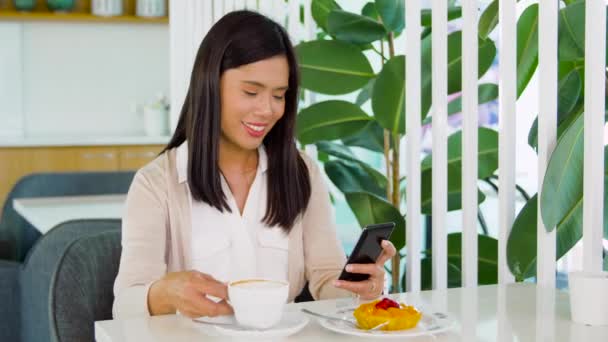 Mujer asiática con teléfono inteligente en la cafetería o cafetería — Vídeos de Stock