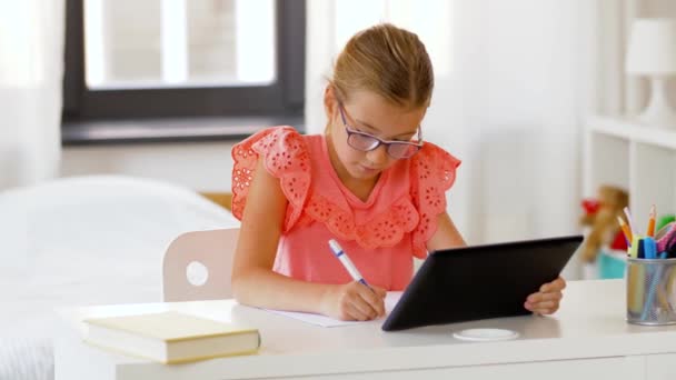 Chica con la escritura de la PC tableta a la libreta en casa — Vídeo de stock