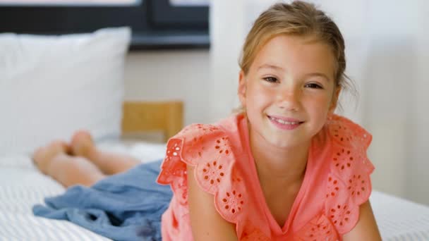 Feliz sorrindo menina bonita deitada na cama em casa — Vídeo de Stock