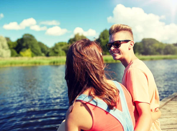 Szczęśliwy nastolatek para siedzi na rzece koja — Zdjęcie stockowe