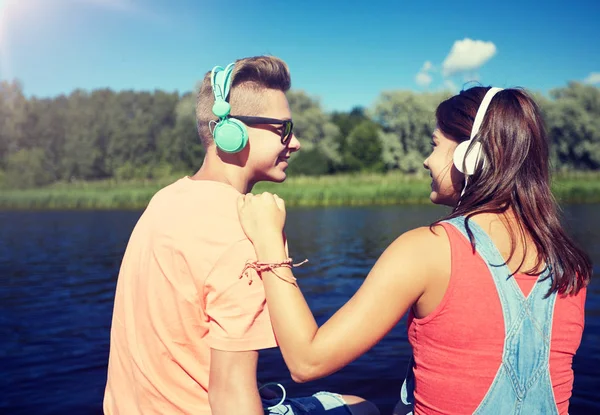 川バースにヘッドフォンで十代のカップル — ストック写真