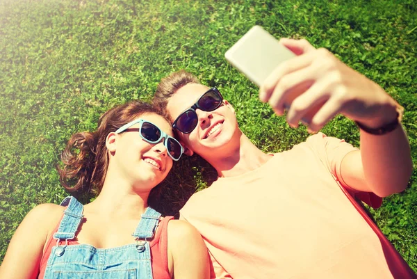 Счастливая пара делает селфи на смартфоне летом — стоковое фото