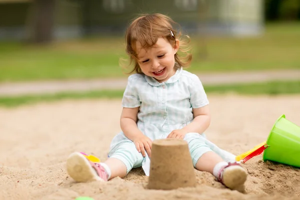 小さな女の子はサンドボックスでおもちゃで遊ぶ — ストック写真