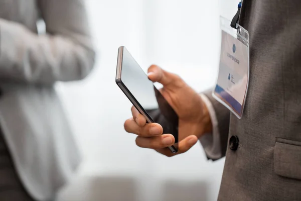 Forretningsmann med smarttelefon på forretningskonferanse – stockfoto