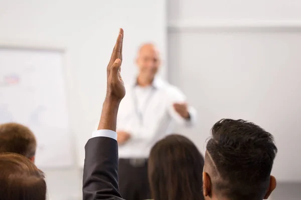 Бизнесмен поднимает руку на бизнес-конференции — стоковое фото