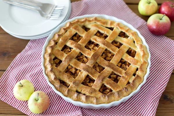 Apple pie in baking mold on wooden table — Stock Photo, Image