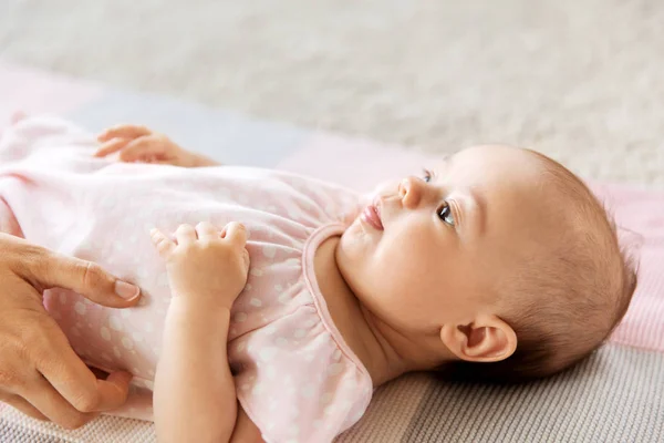 Baby Mädchen auf Decke liegend und Mutter Hand — Stockfoto