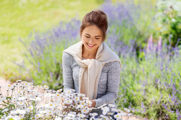 Mujer joven con flores en el jardín de verano —  Fotos de Stock