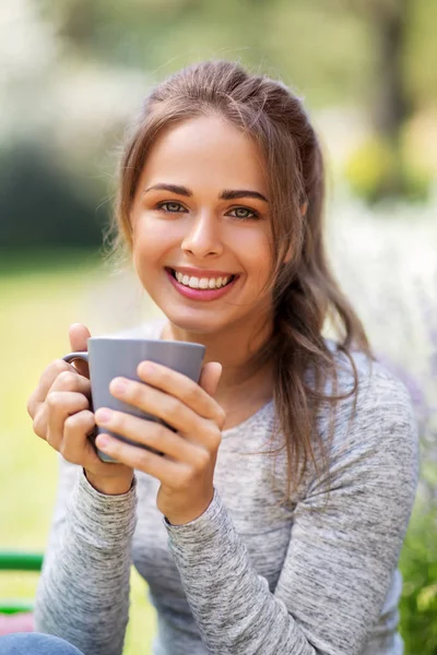 Woman drinking tea or coffee at summer garden — Stock Photo, Image