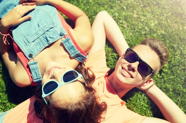 快乐的年轻夫妇在夏天躺在草地上 — 图库照片