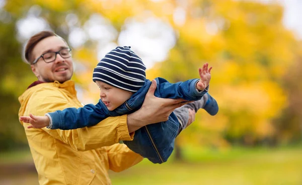 Vater und Sohn spielen und haben Spaß im Herbst — Stockfoto