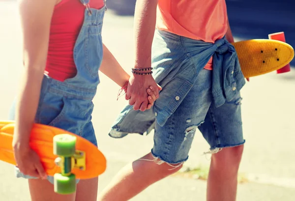 Close up de jovem casal com skates na cidade — Fotografia de Stock