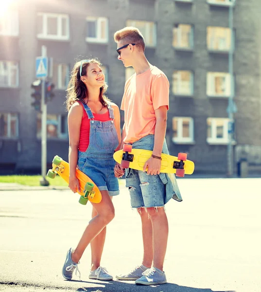 Casal adolescente com skates na rua da cidade — Fotografia de Stock