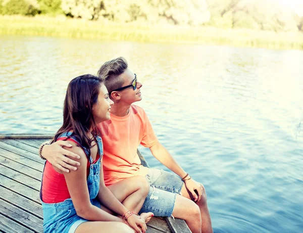 Felice coppia adolescente abbraccio sul fiume ormeggio — Foto Stock