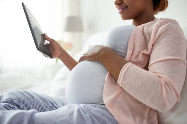 Primer plano de la mujer embarazada con la tableta PC en casa — Foto de Stock