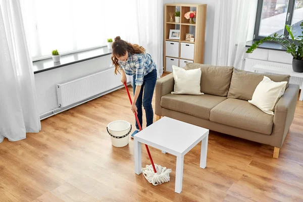 Vrouw of huisvrouw met dweil schoonmaken vloer thuis — Stockfoto