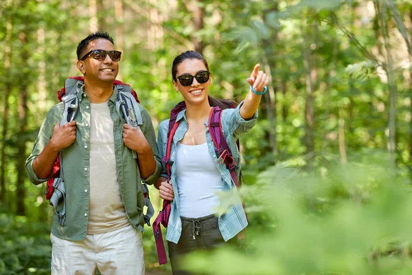 Blandade Race par med ryggsäckar vandring i skogen — Stockfoto