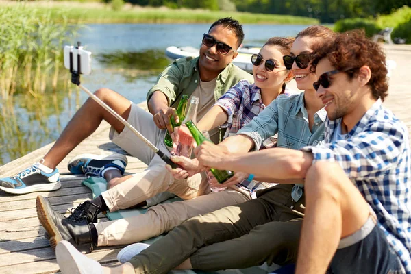 Vrienden met drankjes nemen selfie op Lake Pier — Stockfoto