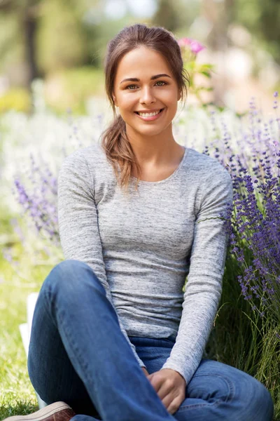 Young woman with flowers at summer garden — Stock Photo, Image