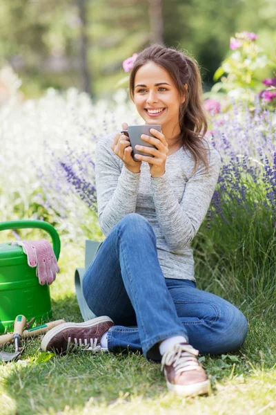 Vrouw drinken thee of koffie in de zomertuin — Stockfoto