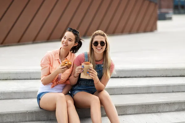 Náctiletých dívek nebo přátel, kteří jedí burgery venku — Stock fotografie