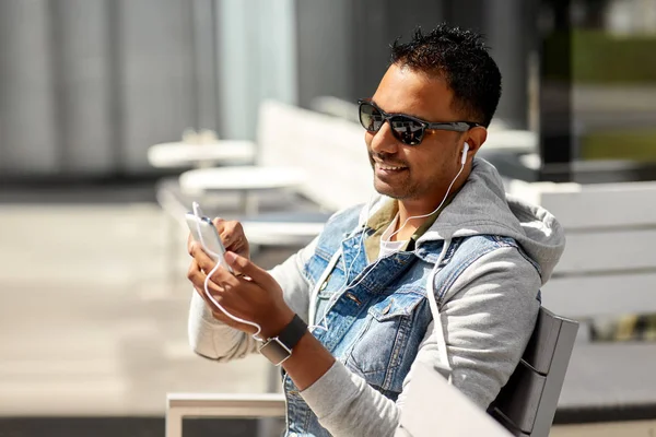Uomo con auricolari e smartphone su City Street — Foto Stock