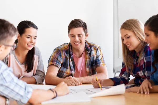 Group of smiling students with blueprint — Stock Photo, Image