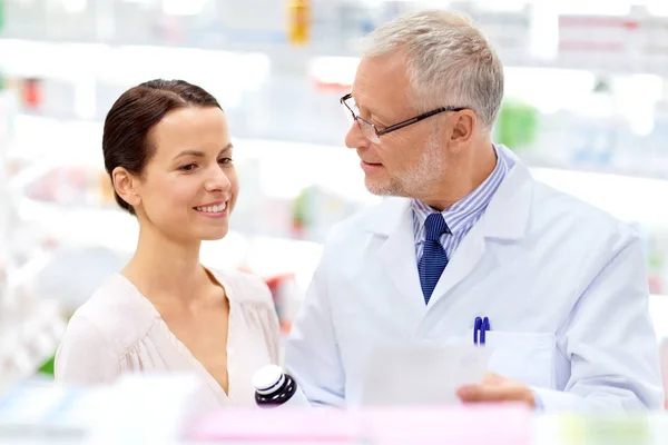 Gyógyszerész és nő gyógyszerrel a gyógyszertárban — Stock Fotó