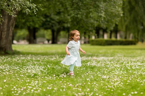 Pequena menina feliz correndo no parque no verão — Fotografia de Stock