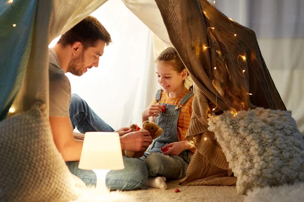 Família feliz brincando com brinquedo na tenda das crianças em casa — Fotografia de Stock
