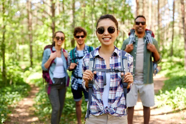 Vänner med ryggsäckar på vandring i skogen — Stockfoto