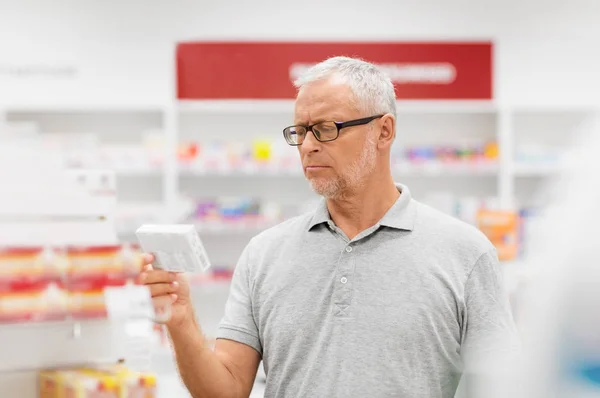 Senior male customer with drug at pharmacy — Stock Photo, Image