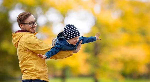 Far med sønn som leker og har det gøy om høsten – stockfoto