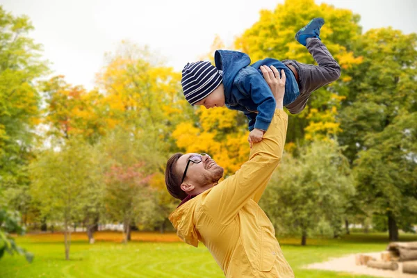 Padre con hijo jugando y divirtiéndose en otoño — Foto de Stock